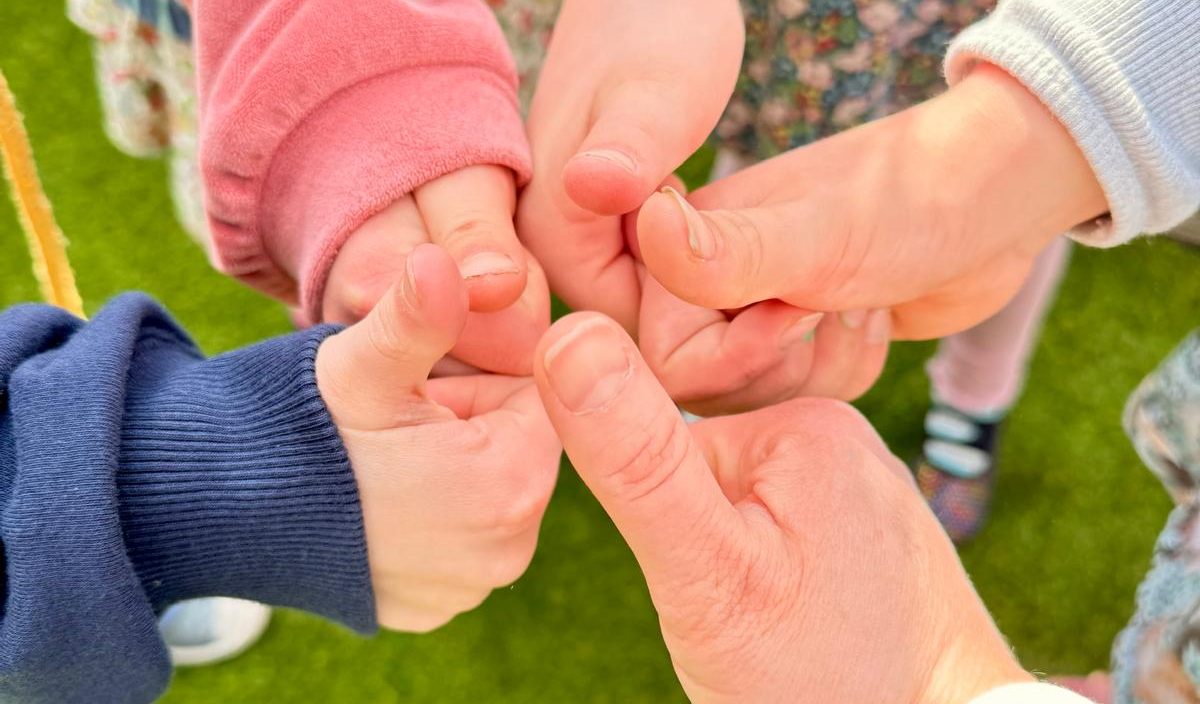 Gemeinsam bei den Taunuskids Mehrere Hände berühren sich in der Mitte zu einem Kreis.